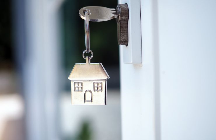 chiave nella toppa e casa in miniatura