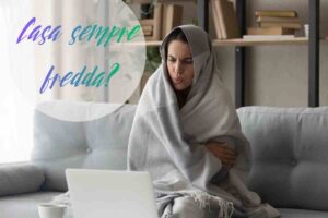 ragazza con il plaid sul divano che sente freddo