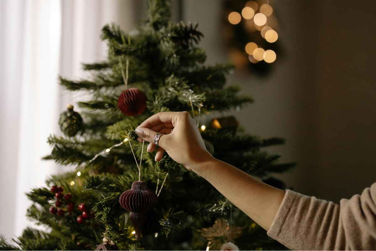 Donna che addobba l'albero di Natale