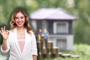 casa in miniatura e spicciola e donna che fa ok con le mani