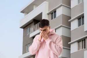 Un condominio sullo sfondo ed in primo piano un condomino preoccupato