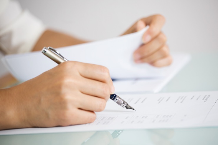 Una persona che firma documenti e fogli