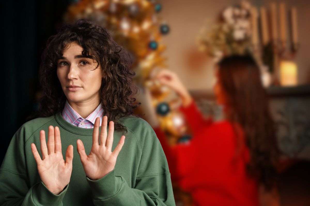 donna che addobba l'albero e un'altra che fa stop con le mani