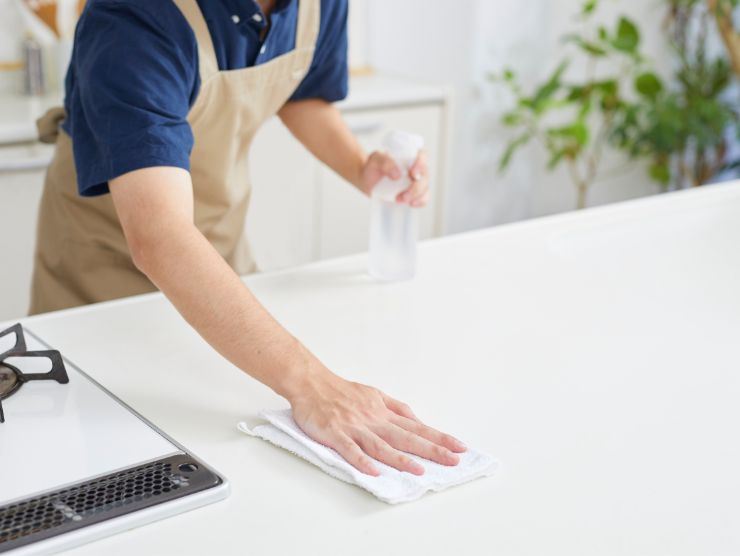 persona che pulisce superficie della cucina