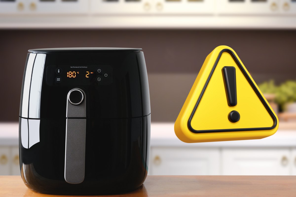 Una friggitrice ad aria e alla sua destra un segnale di pericolo