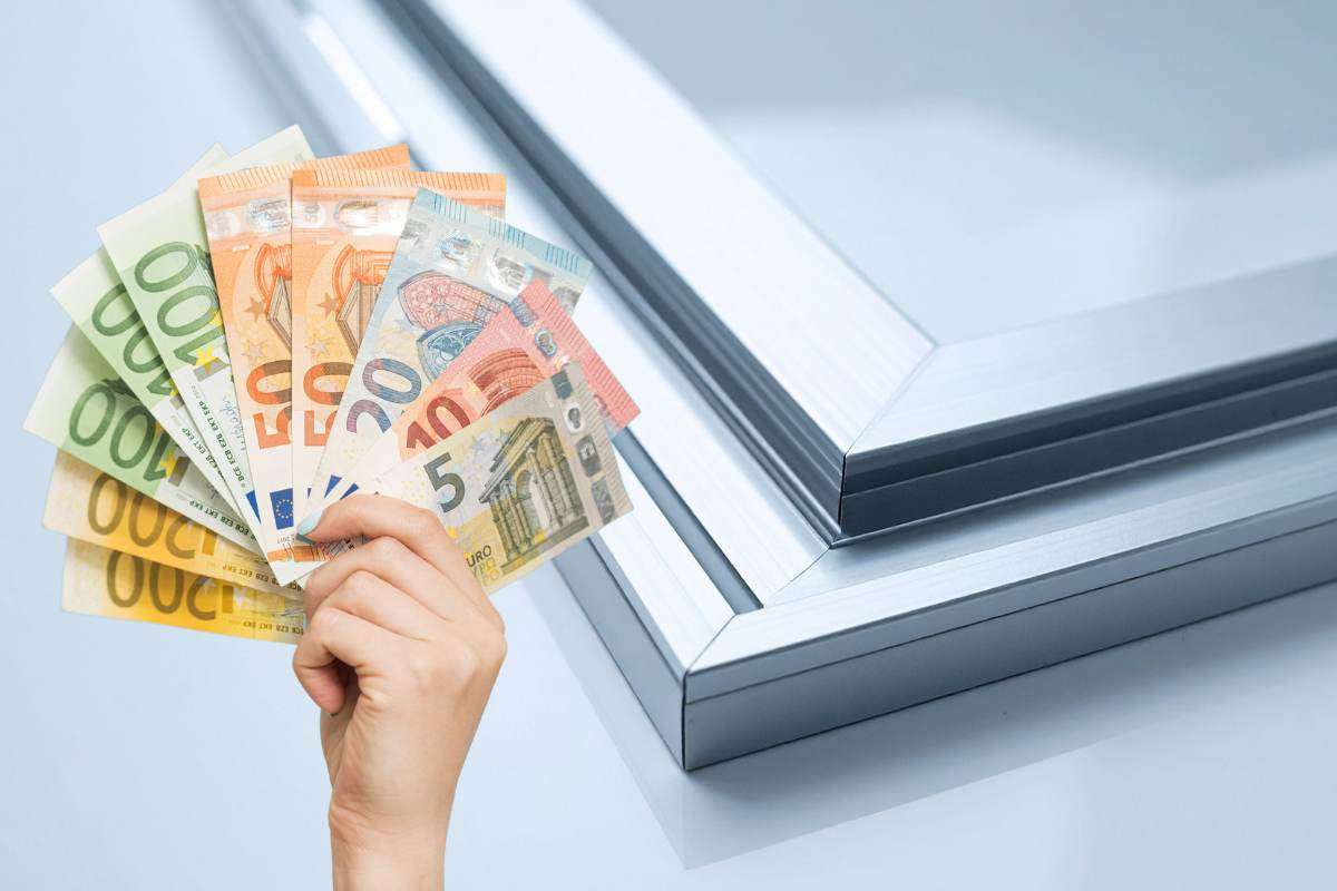 mano con banconote e finestra