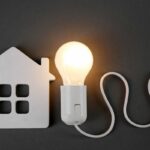 Una miniatura di una casa fatto in plastica e una lampadina accesa