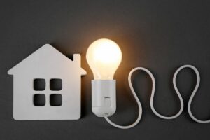 Una miniatura di una casa fatto in plastica e una lampadina accesa