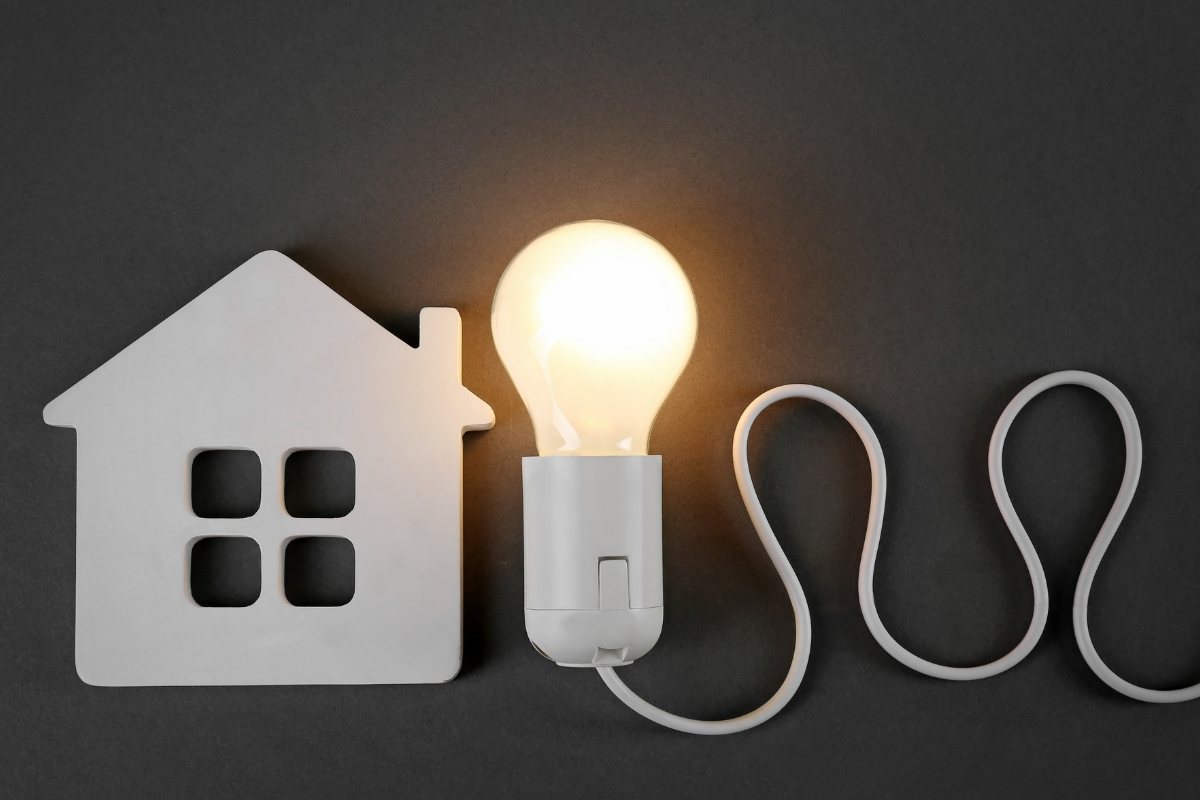 Una miniatura di una casa fatto in plastica e una lampadina accesa