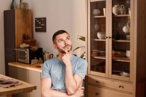 Un salone allestito con mobili in legno ed una persona pensierosa