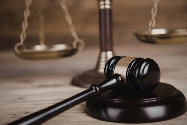 Una bilancia di giustizia sul retro ed in primo piano un martello da giudice