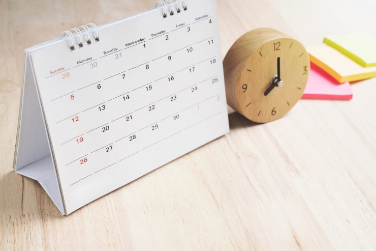Un tavolo con sopra un calendario ed un orologio