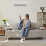 donna sul divano che accende pompa di calore