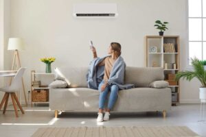 donna sul divano che accende pompa di calore