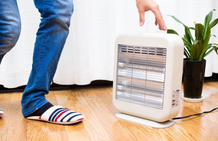 uomo accanto a stufa elettrica 