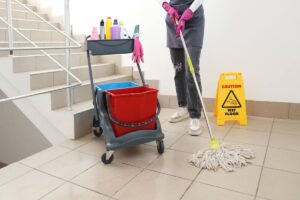 Una persona delle pulizie che sta pulendo le scale di un condominio