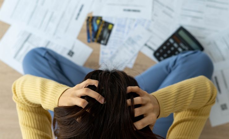 donna disperata con bollette e calcolatrice