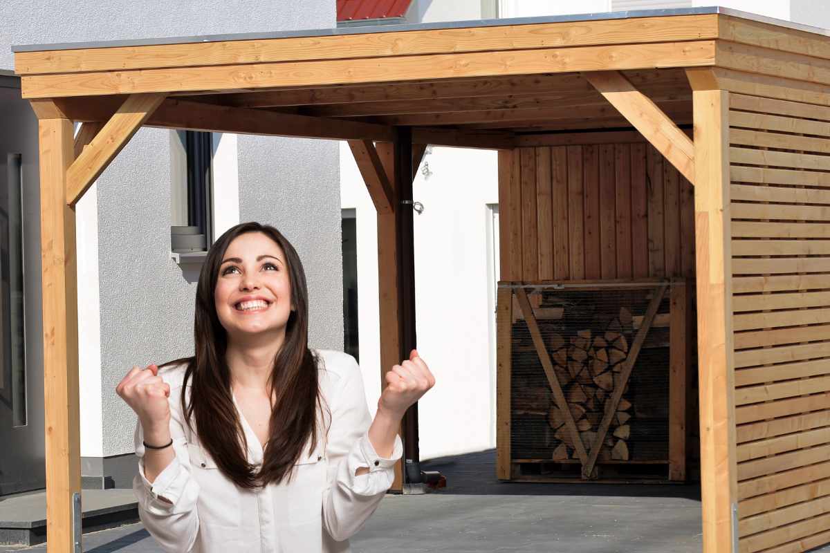 Un gazebo in legno irregolare ed una donna che esulta