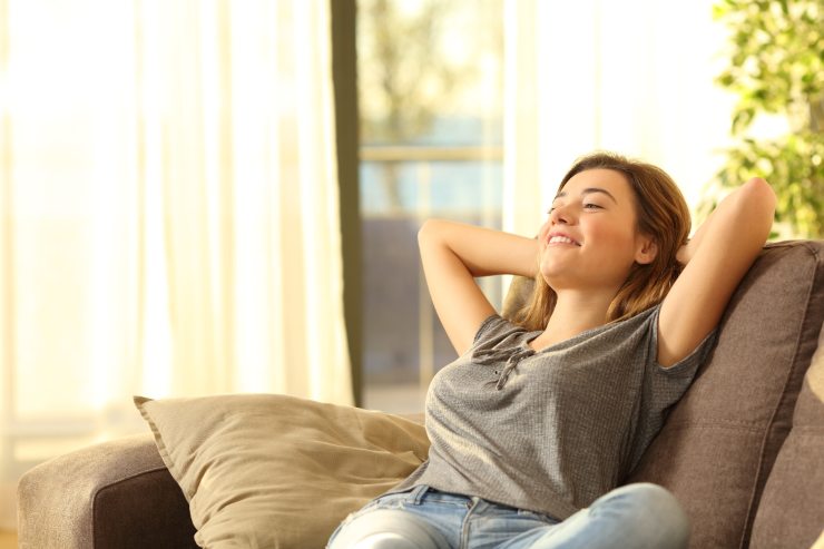 Una donna che riposa serena sul suo divano