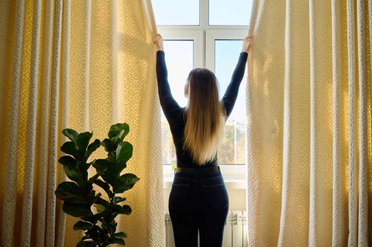 Una ragazza che chiude le tende