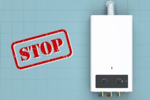 Una caldaia appesa ad un muro e sulla sinistra la scritta "Stop"