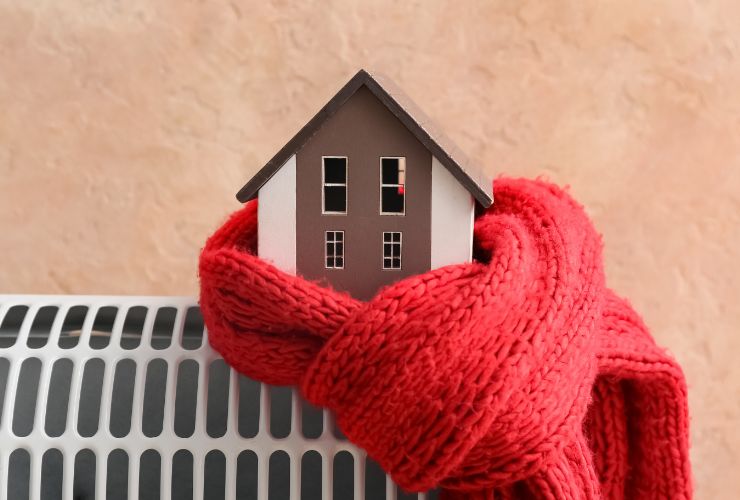 sagoma casa avvolta in una sciarpa su termosifone 