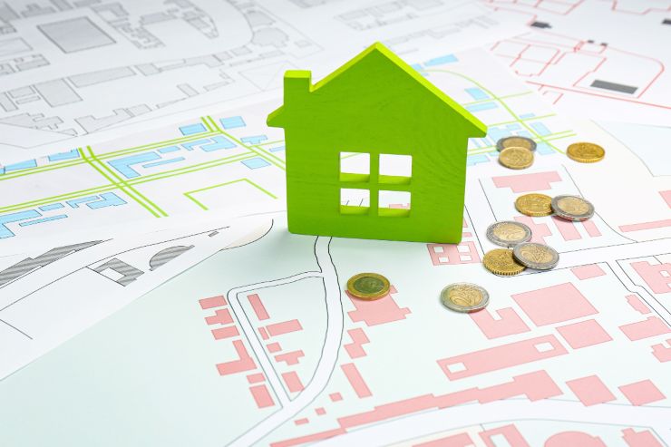 una miniatura di una casa sopra una cartina catastale e delle 