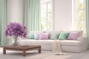 soggiorno con divano bianco Cloud Dancer e cuscini color pastello