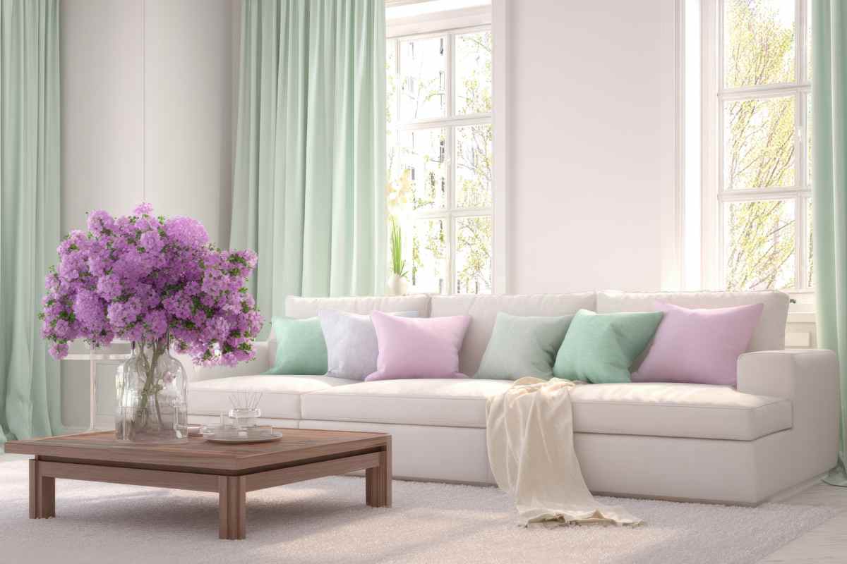 soggiorno con divano bianco Cloud Dancer e cuscini color pastello