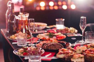 Tavola apparecchiata con bicchieri di cristallo e bottiglie di vino