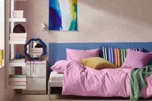 una stanza con un divano letto con copripiumino rosa