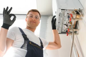 Un operaio che controlla la caldaia e fa cenno di approvazione con la mano