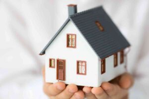 mano sorregge un modellino di casa