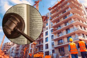 cantiere edile con gru e operai con martello da giudice in evidenza