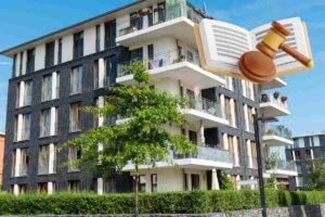 Un condominio sullo sfondo e una grafica in alto a desta di un libro di legge con un martello da giudice ed una base del martello