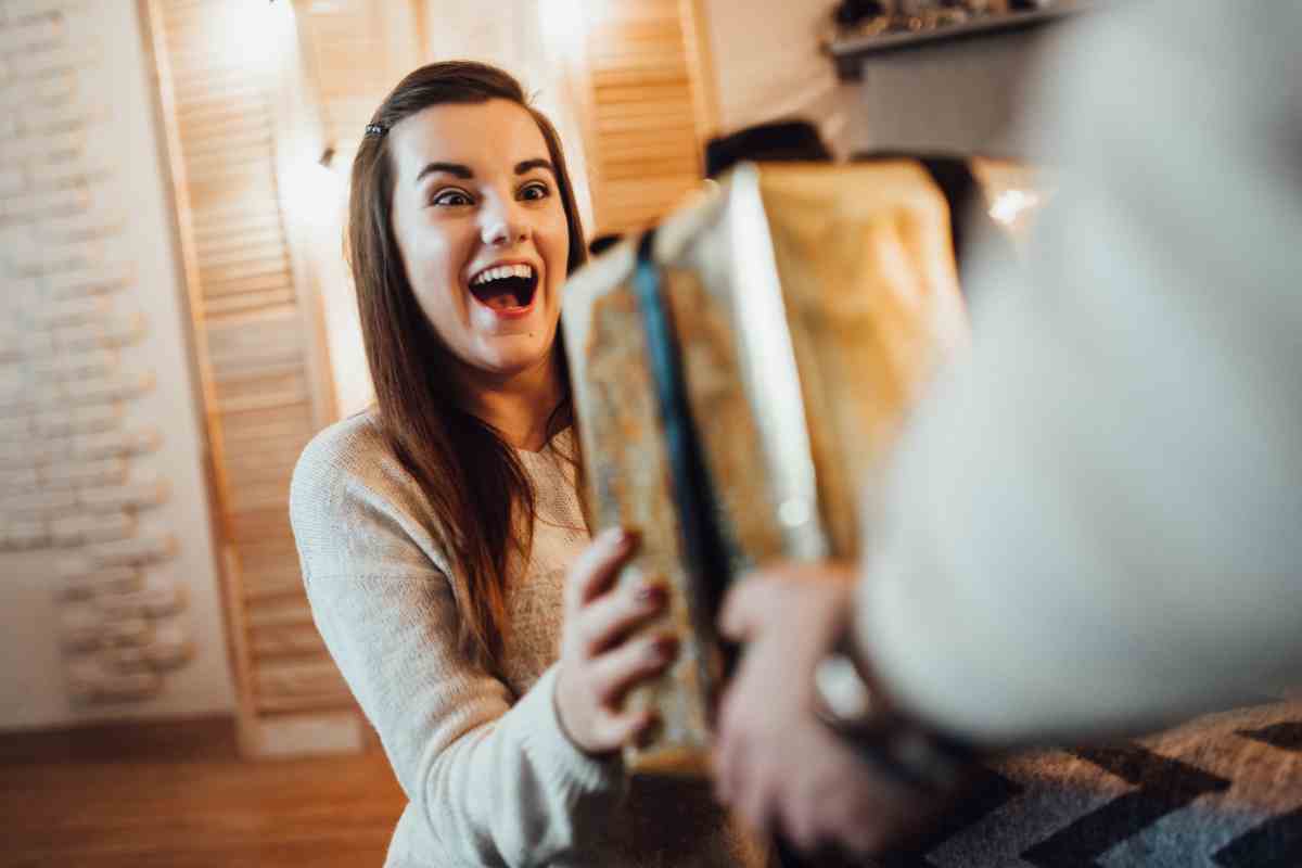 ragazza felice riceve un regalo di Natale con dentro il mappamondo di design