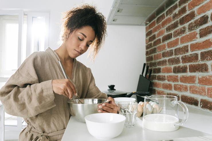 Una donna che cucina sulla penisola della sua cucina