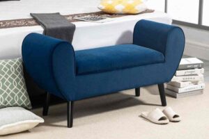 Panca contenitore Maury's ai piedi di un letto con due cuscini vicino