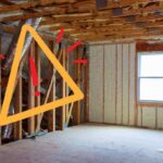 Una casa con dei pannelli isolanti ed un segnale di pericolo sulla sinistra