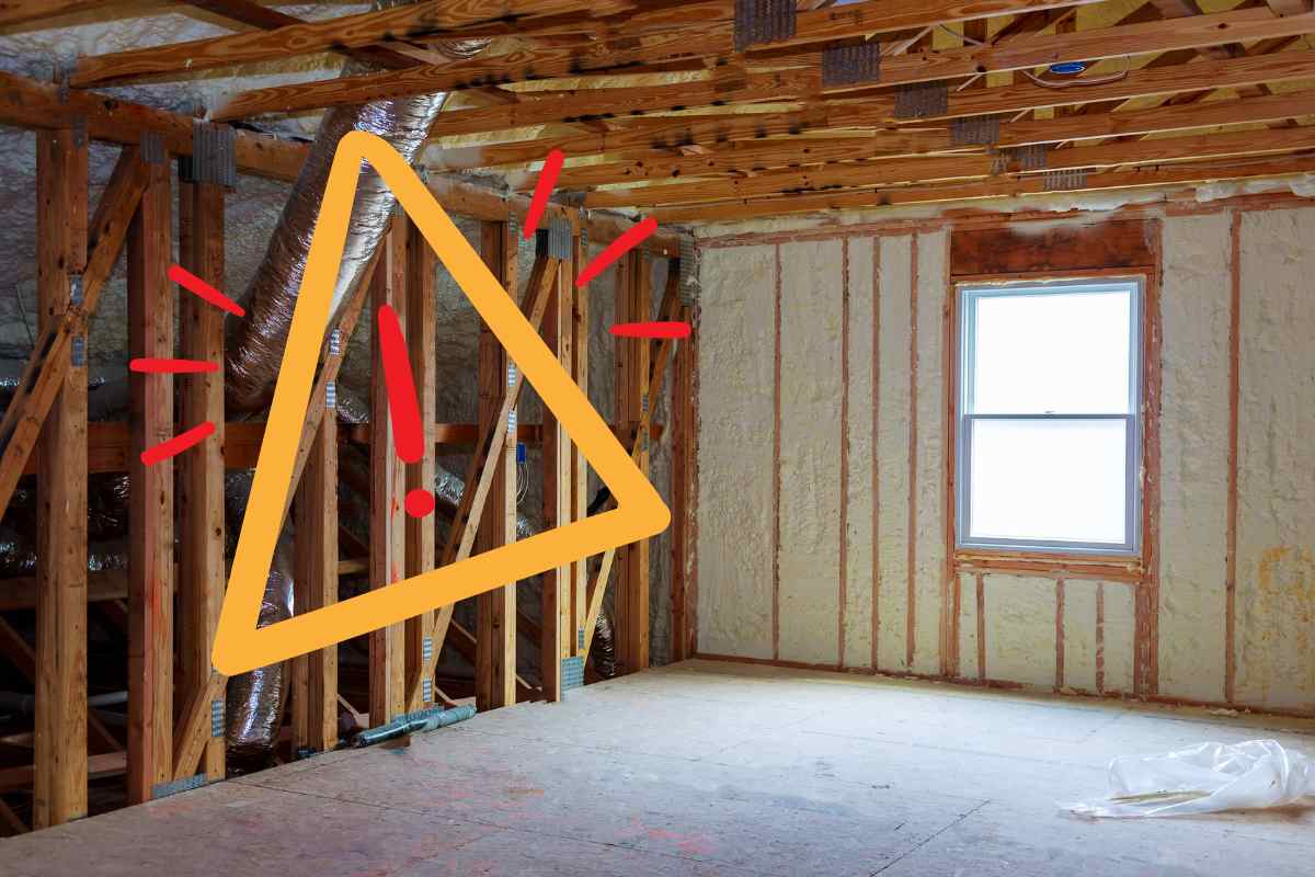 Una casa con dei pannelli isolanti ed un segnale di pericolo sulla sinistra