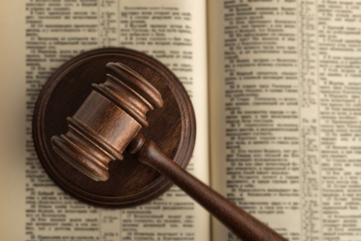 Un libro di legge con sopra un martelletto da giudice