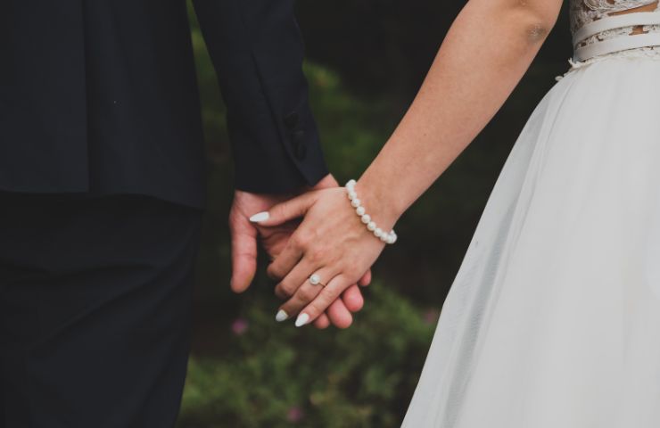 Una coppia di sposi che si tiene per mano
