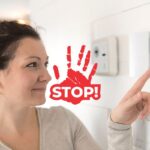 Una donna che sta impostando la temperatura sul termostato