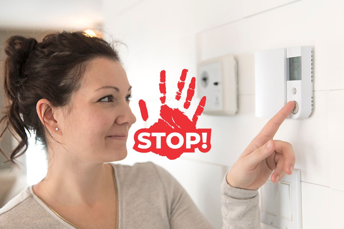 Una donna che sta impostando la temperatura sul termostato