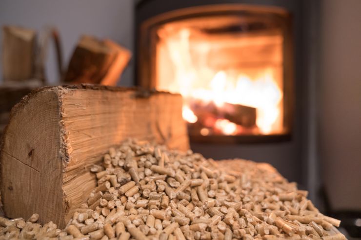 Del pellet in primo piano ed una stufa sullo sfondo