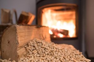 Una stufa a pellet in funzione sullo sfondo e in primo piano il pellet