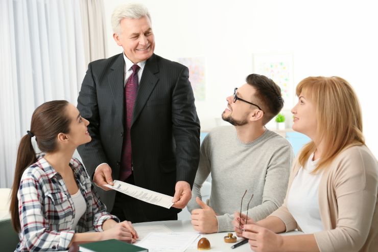 Dei parenti attorno ad un notaio che sta comunicando loro l'eredità