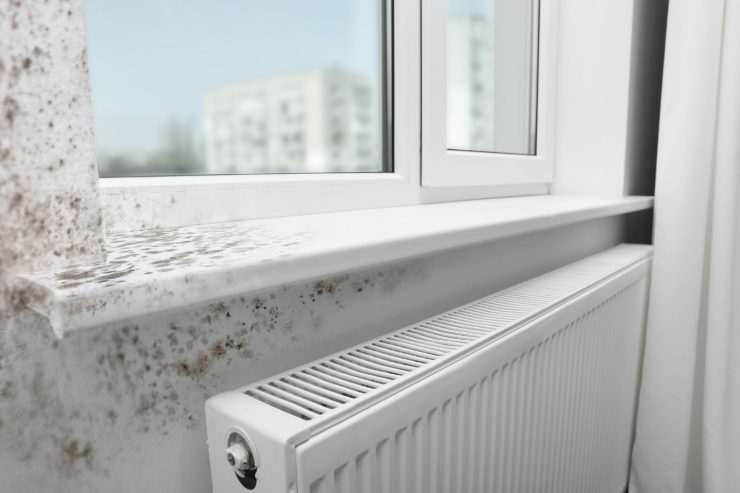 Un parete con macchie di umidita vicino al termosifone