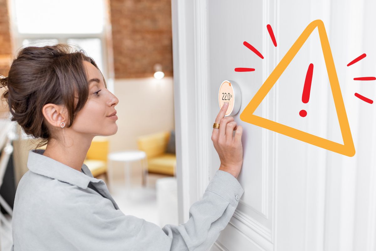 Una donna che imposta i termostati e un segnale in alto a destra di pericolo
