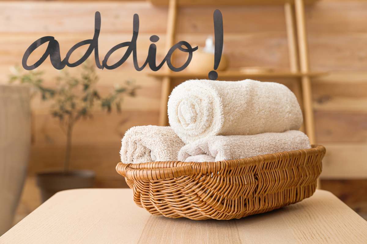 Dei panni piegati dentro una cesta sopra al tavolo ed una scritta in alto "addio!"